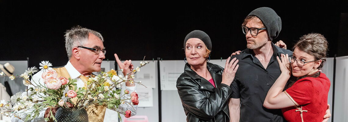 Mutter und Frau an Richard gelehnt. Der Freund sprechend mit Blumen in der Hand.